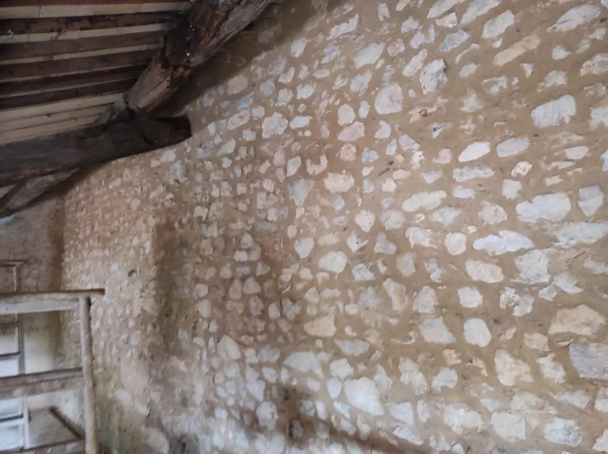 Muro in sasso con arco e stilatura chiara