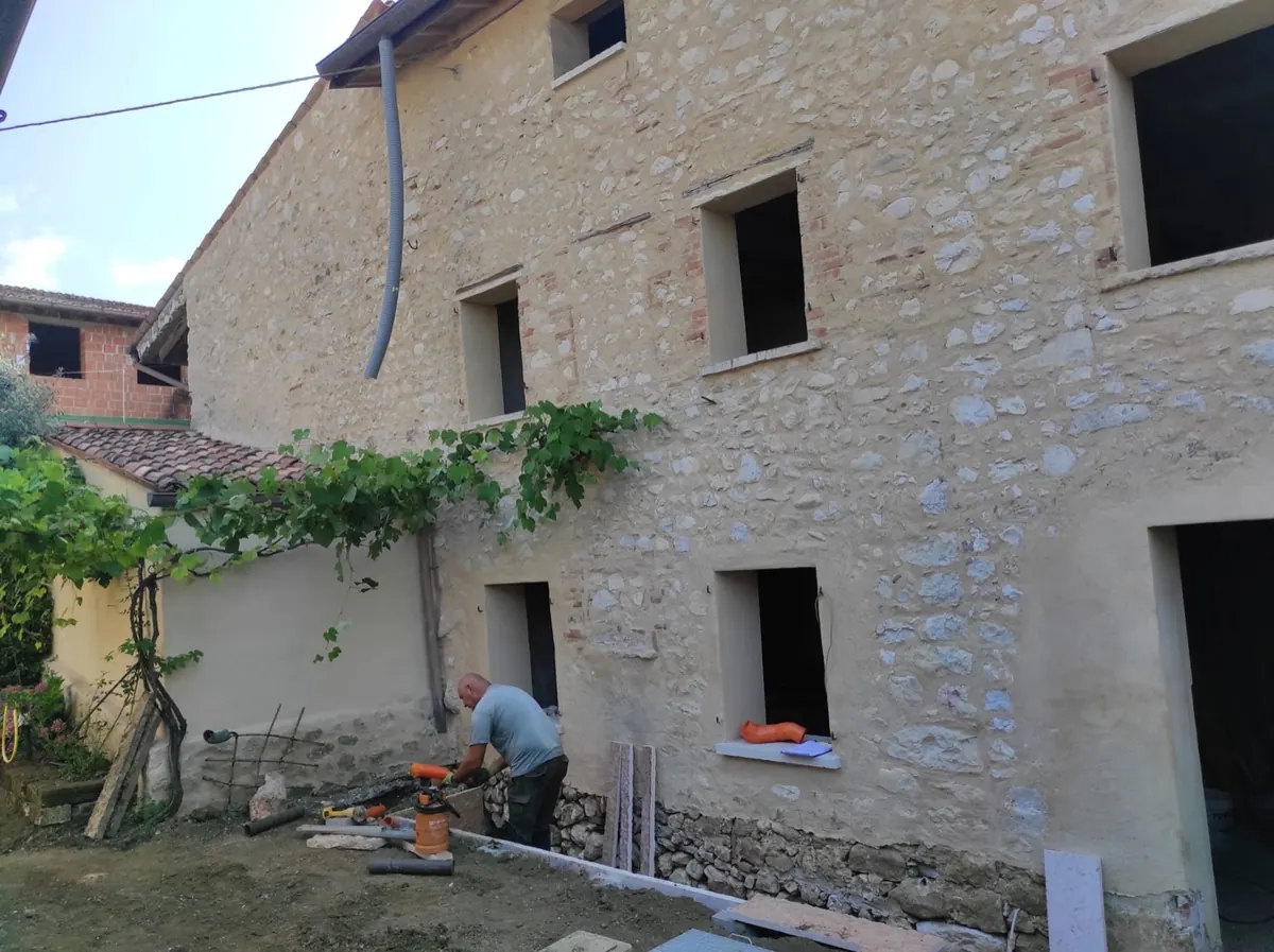 Edificio in sasso durante i lavori, con ponteggio montato