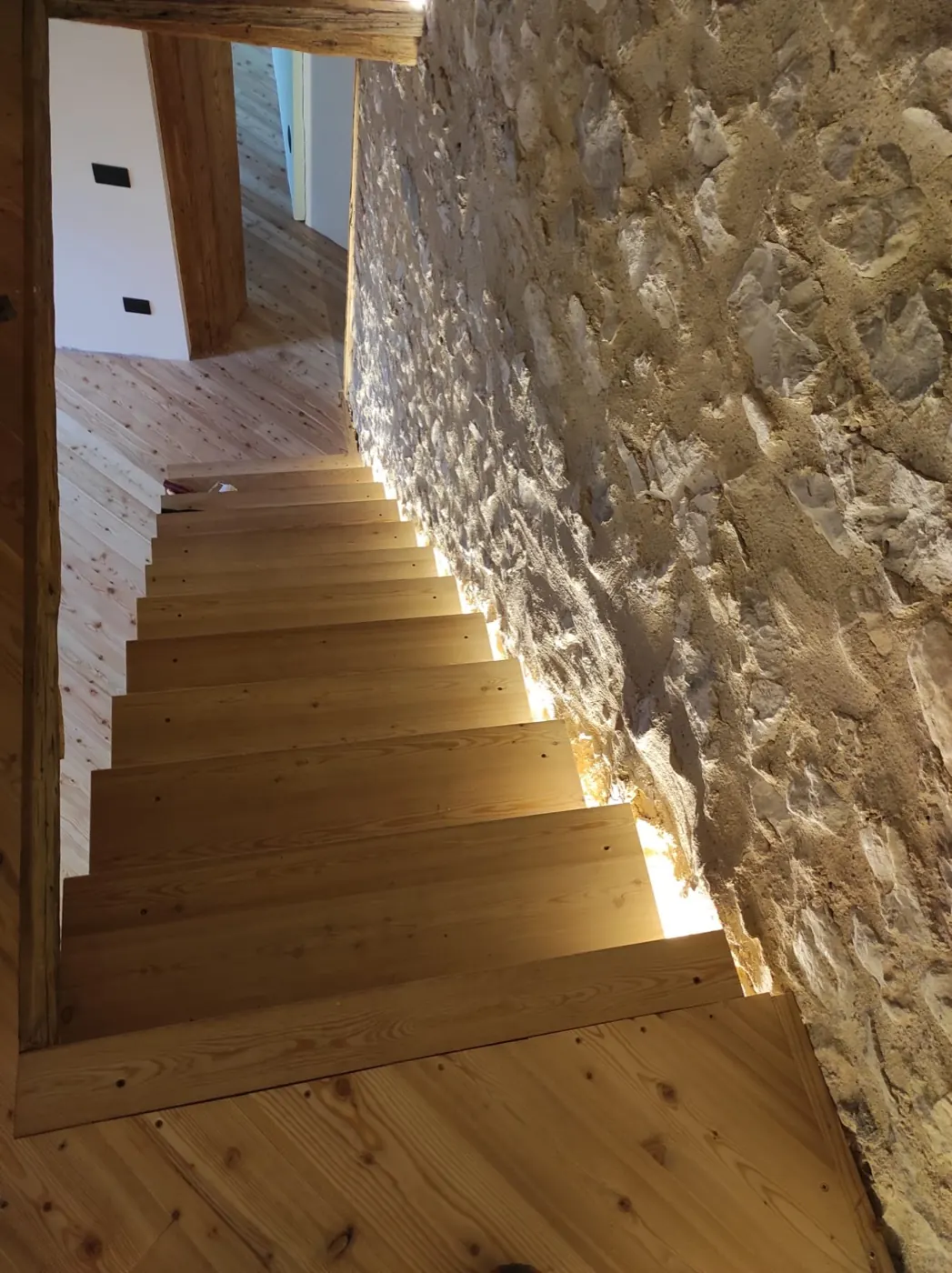 Scala interna con parete in sasso a vista